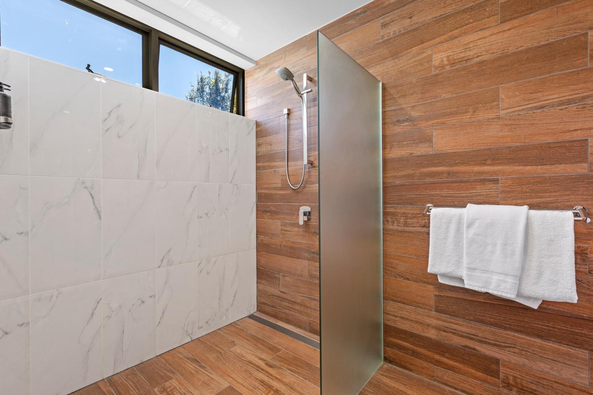 Altitude On Montville Pokoj fotografie A shower with a fixed shower head and handheld shower head